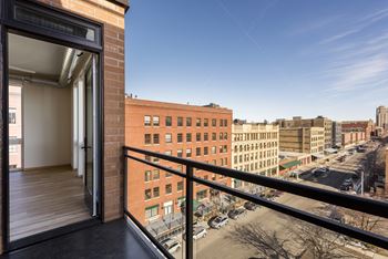 A balcony with a view of a city street and buildings.